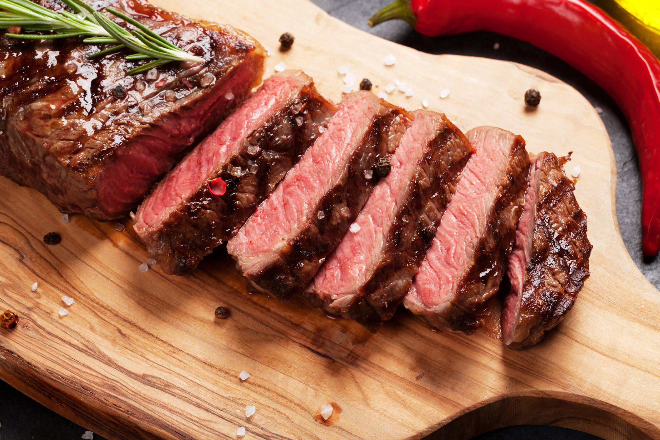 A beef steak sliced on a cutting board.