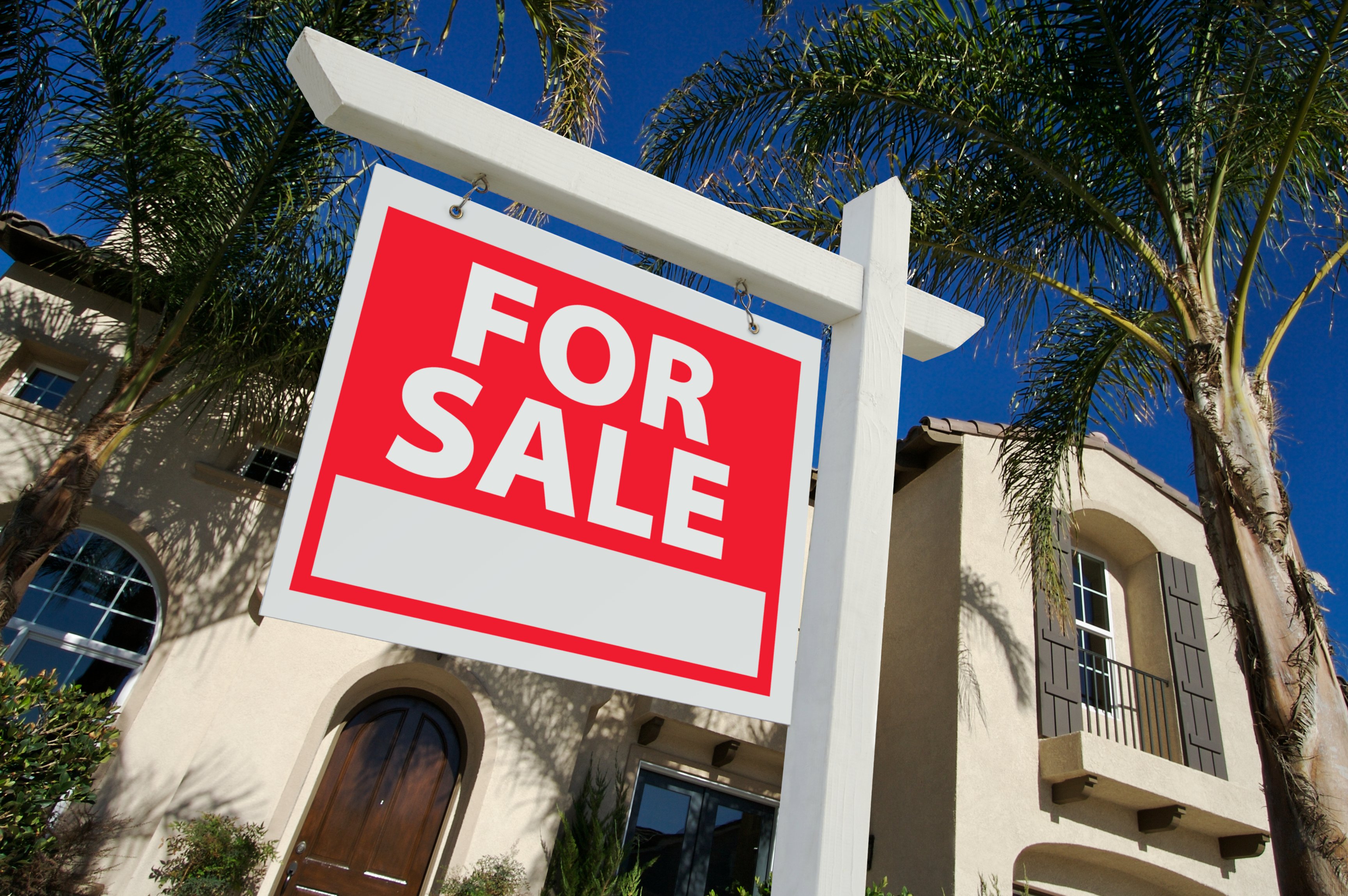 A "for sale" sign in front of a house.