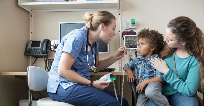 A healthcare worker checking a child's temperature.