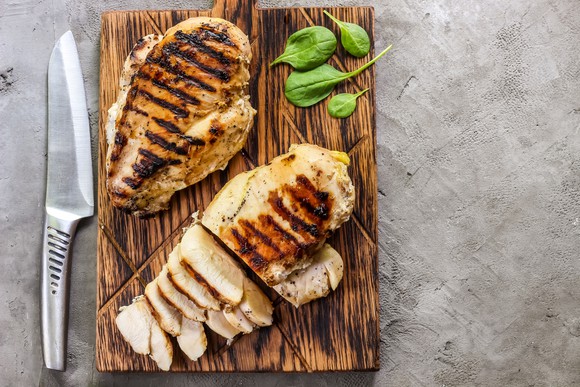 Grilled chicken breasts on a cutting board