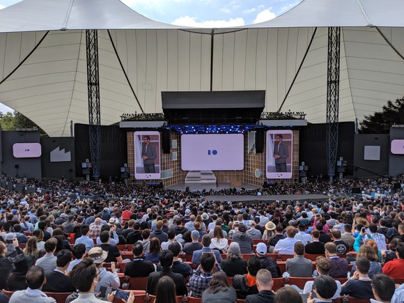 A crowded stadium with a man on stage.