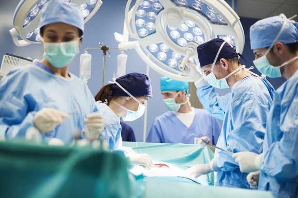 Surgeons are shown in an operating room as they work.