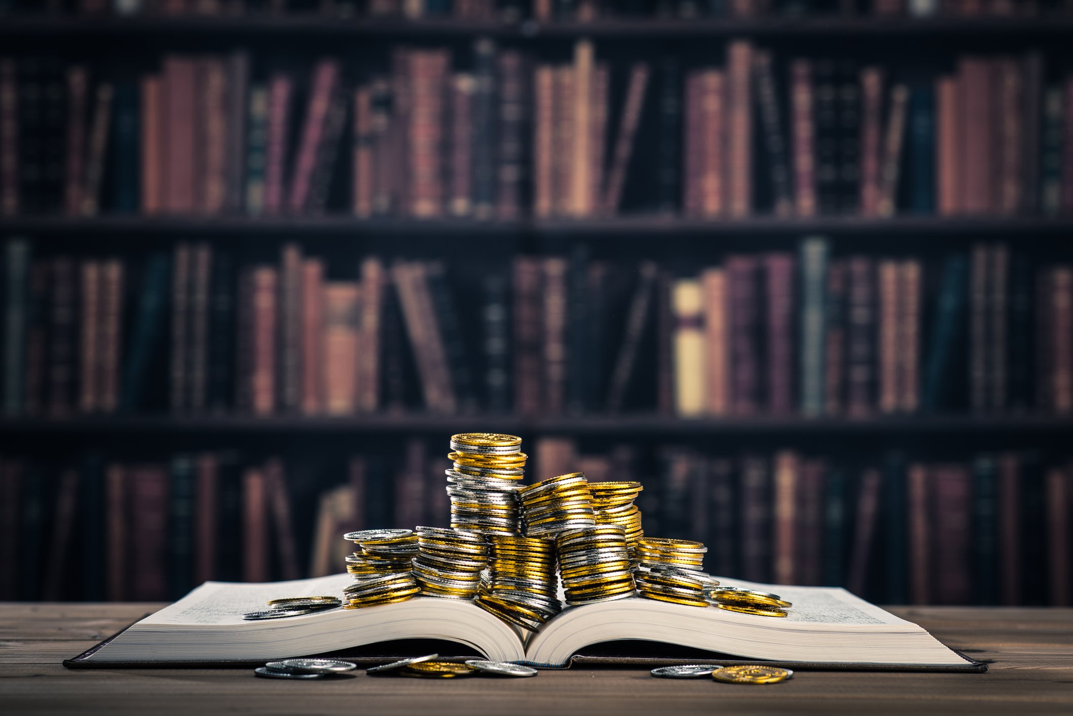 Piles of gold coins on top of a book.