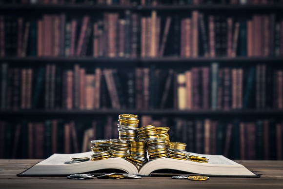 Piles of gold coins on top of a book.