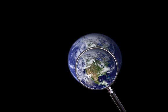 A magnifying glass over Earth, highlighting North America.