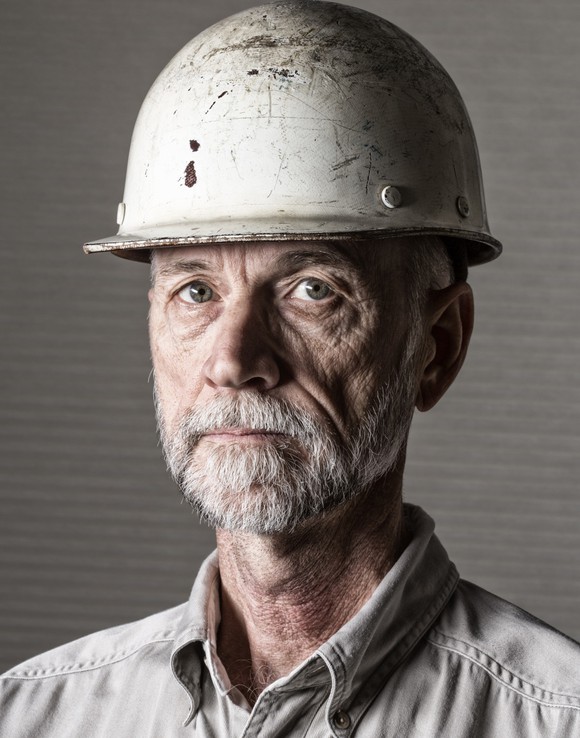  Person wearing hard hat and collared shirt.