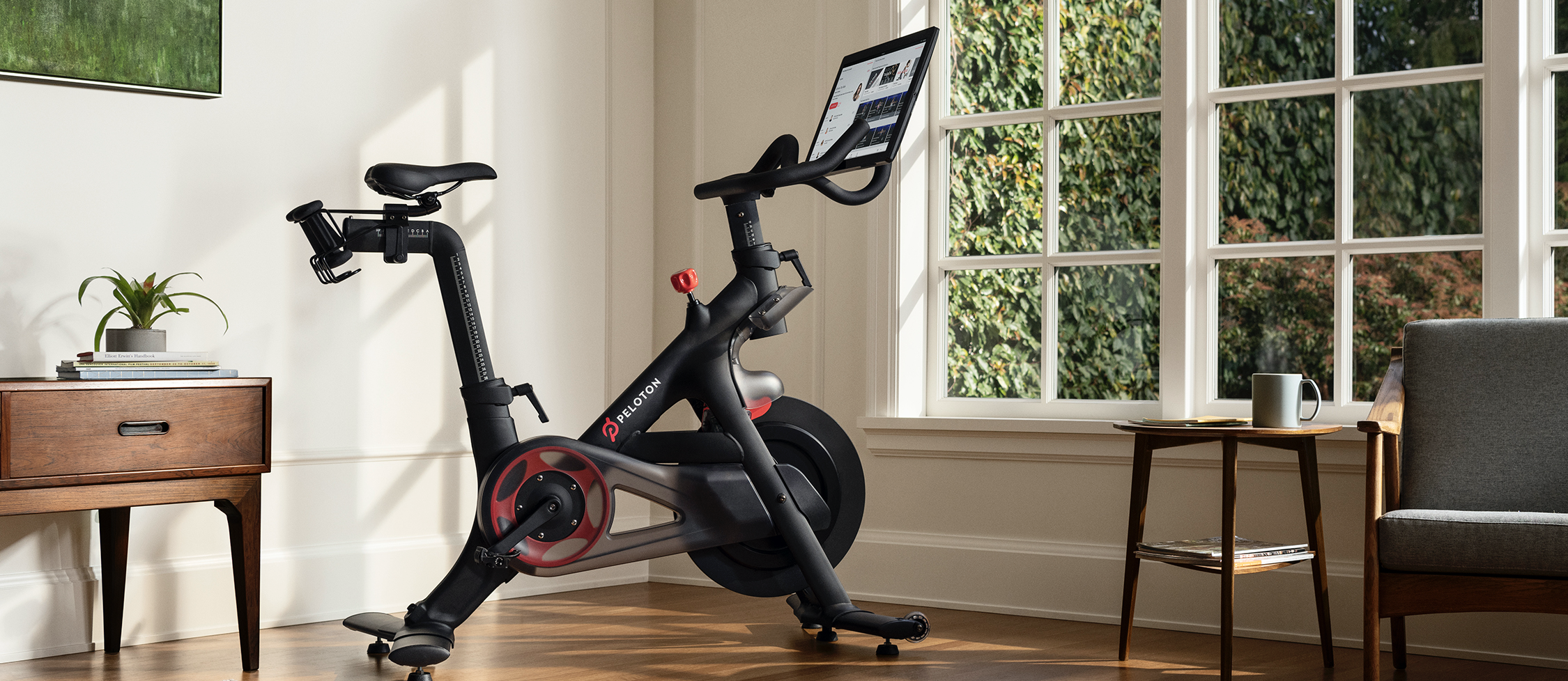 A Peloton exercise bike sitting in a living room.