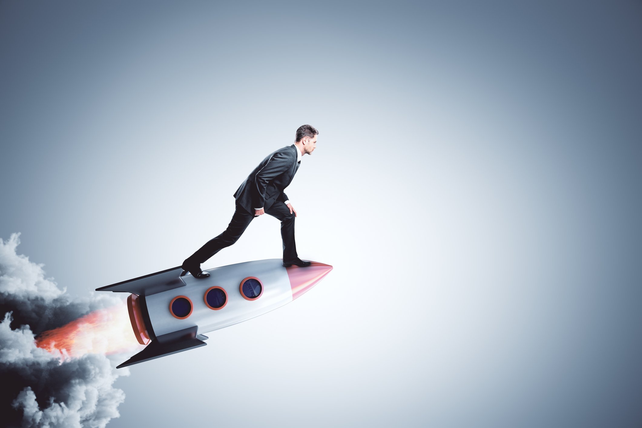 A man in a suit stands on a rocket ship.