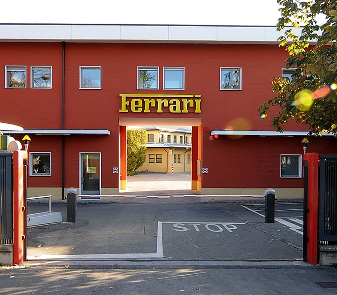 A red building with the Ferrari name, the landmark entrance to Ferrari's factory complex. 