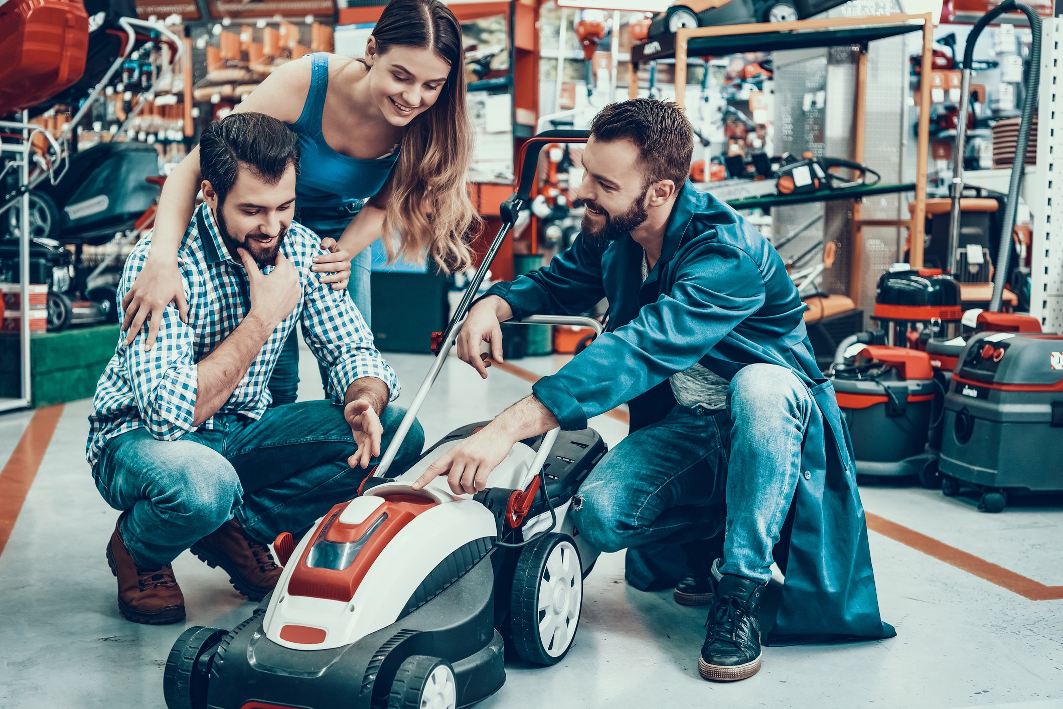 People looking at a lawn mower in a retail store