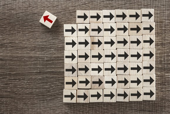 A red arrow pointing away from a bunch of black arrows