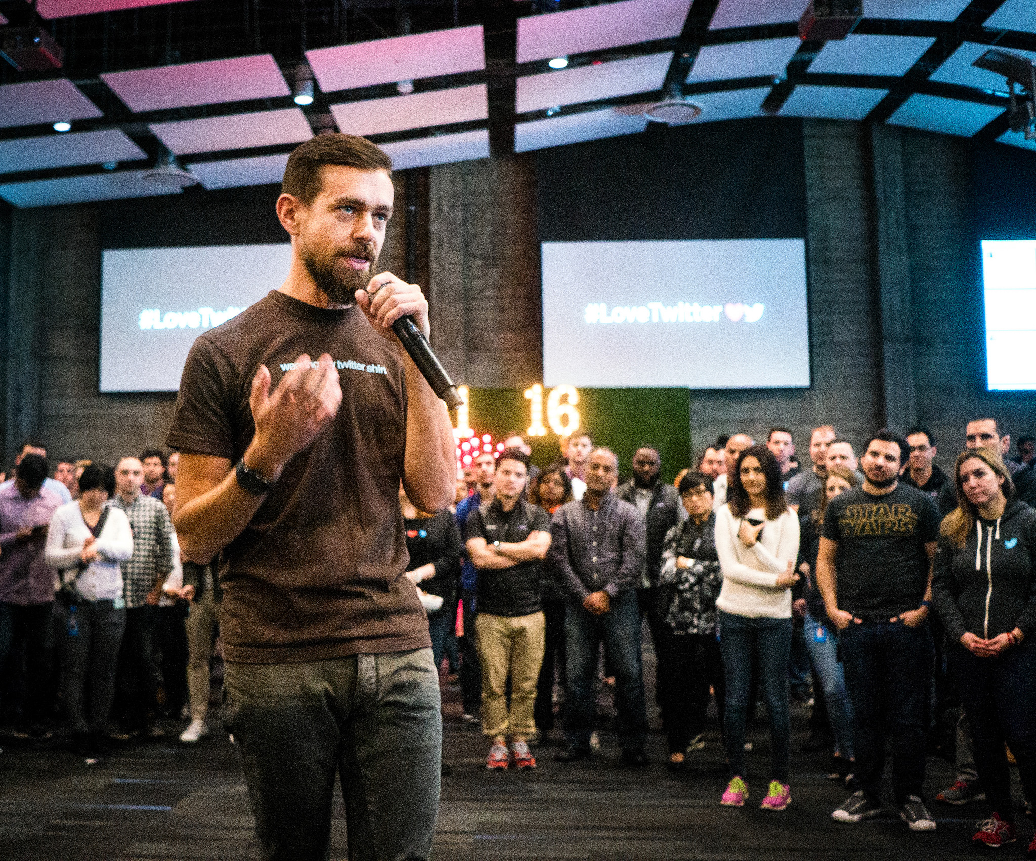 Jack Dorsey holding a microphone in front of a crowd.