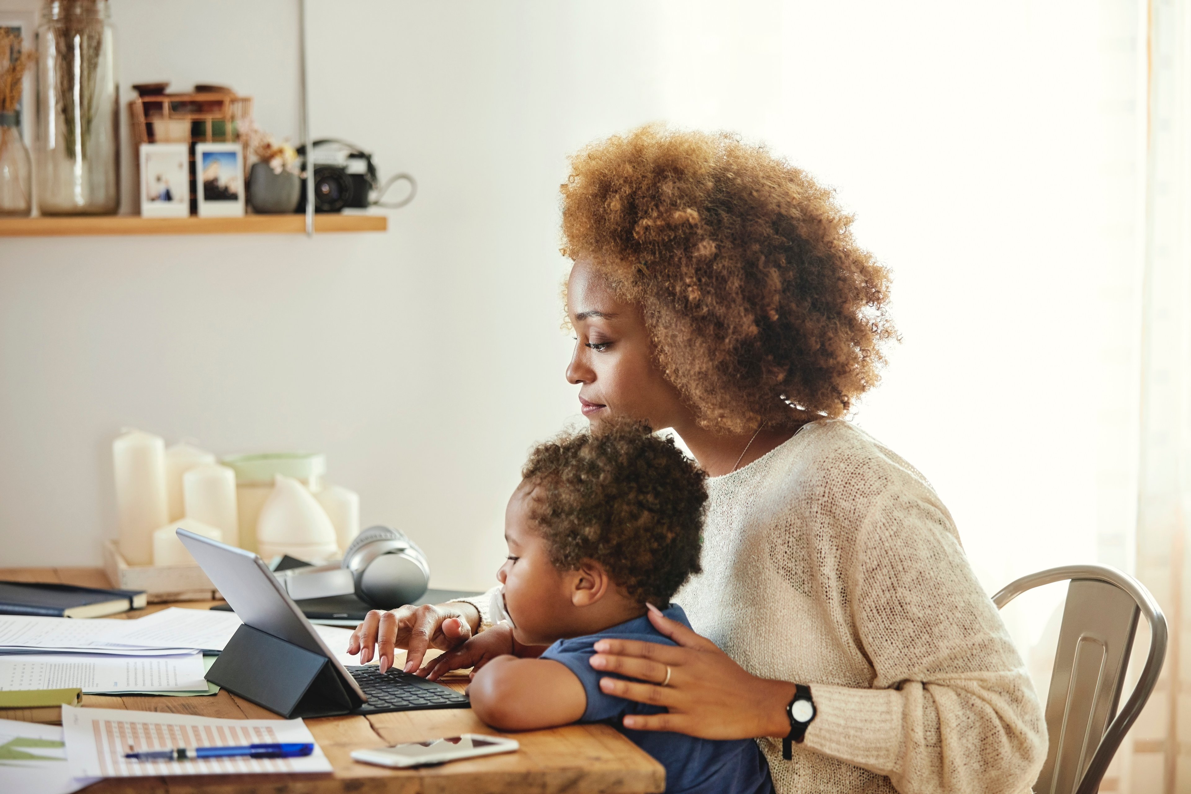 Woman working from home with child on lap.