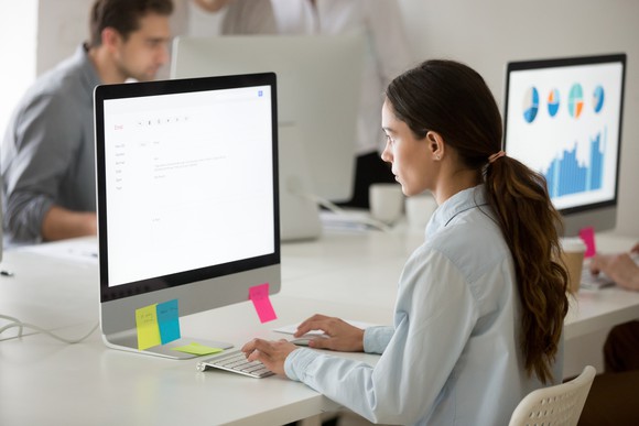 People using desktop computer on large desk.