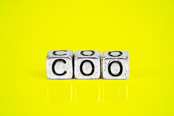 Three blocks that spell out COO on a yellow background