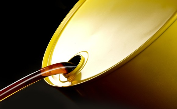 Oil pours from a golden barrel.