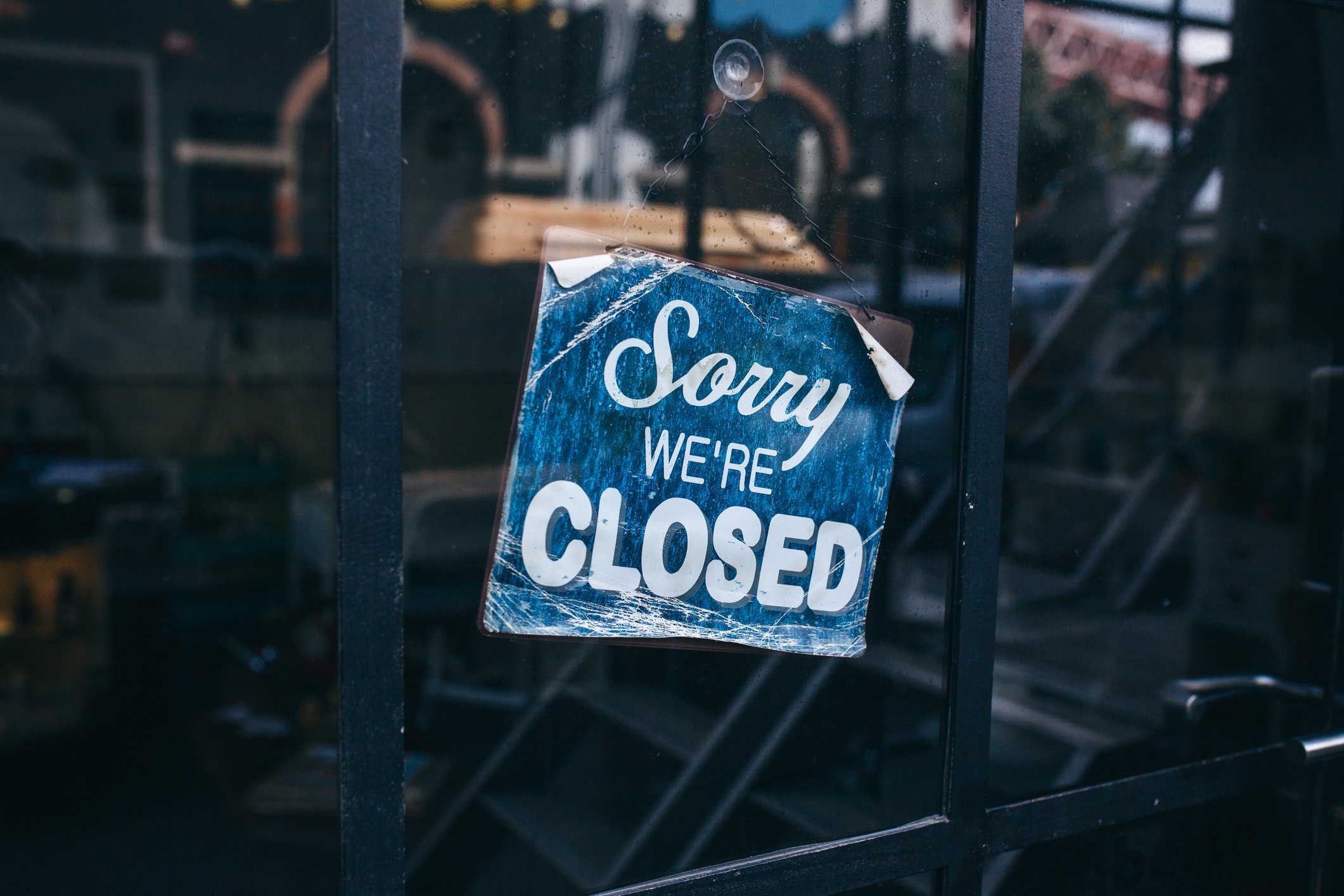 "Sorry, we're closed" sign in a store window.