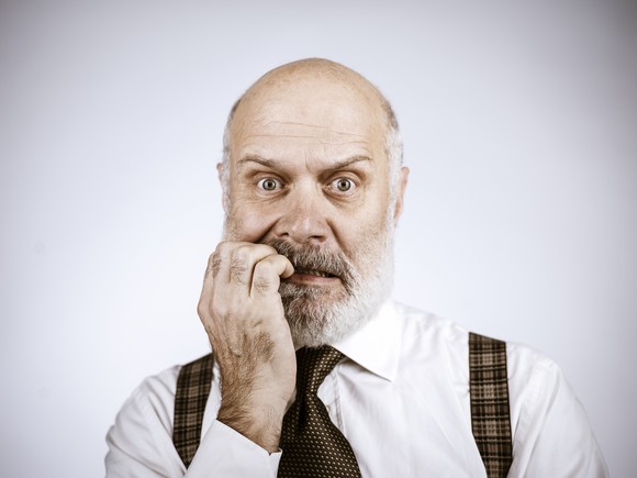 A businessman biting his fingernails.