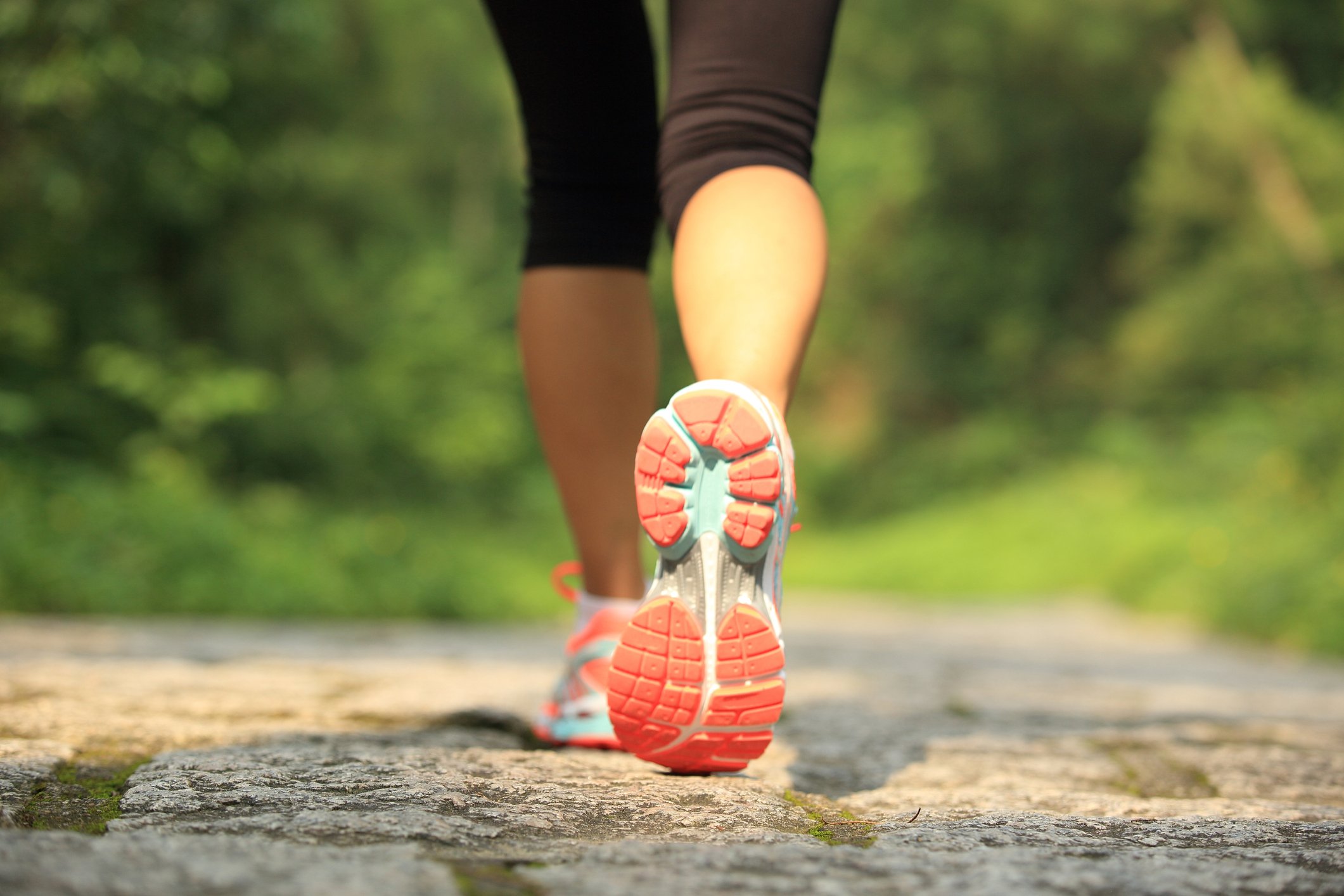 Close-up of a woman's shoe as she runs on a trail.