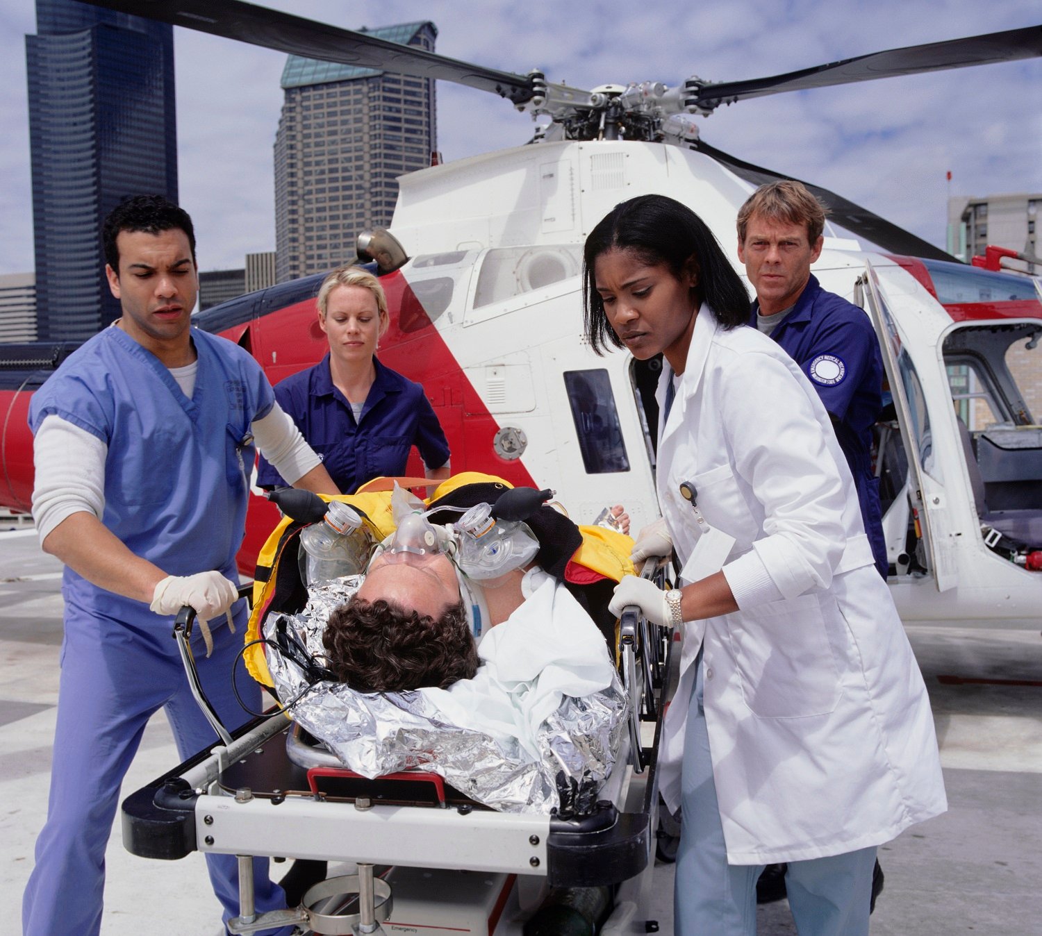 Patient on gurney being transported by helicopter.