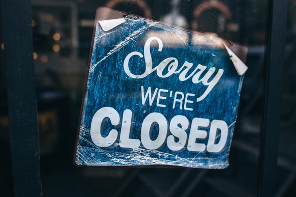 Sorry We're Closed sign hung in window