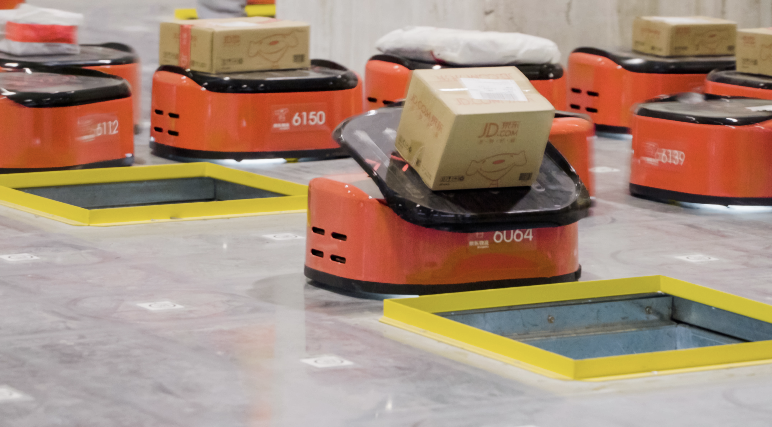 Automated bots sorting packages in a warehouse facility operated by JD.com.