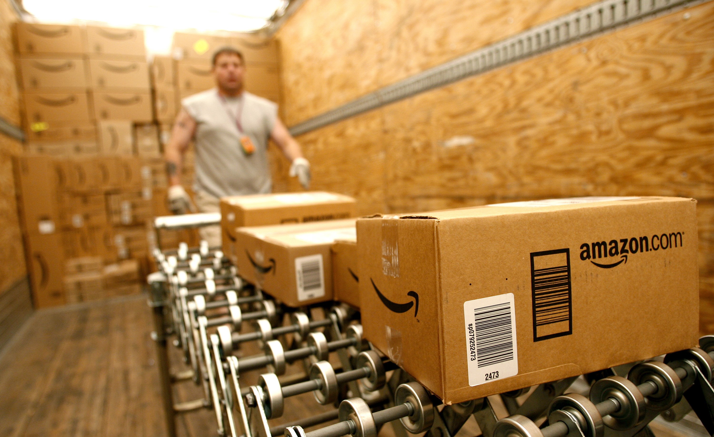 Amazon worker loading Amazon boxes on a conveyor belt