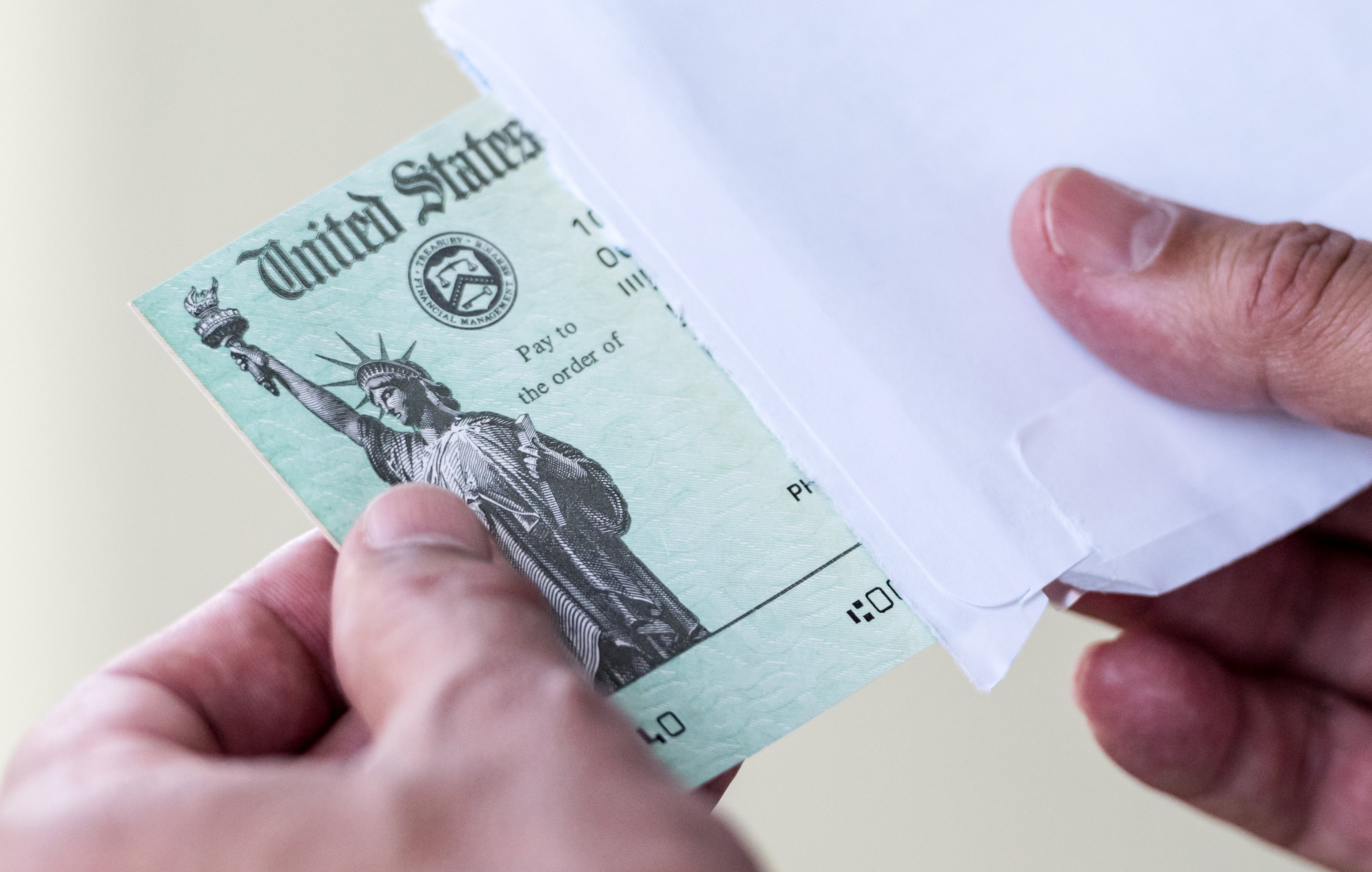 A person receiving a check in the mail from the U.S. government.