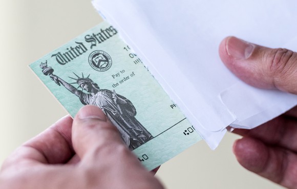 A person receiving a check in the mail from the U.S. government.