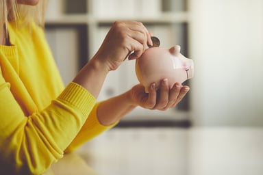 Woman putting money in piggy bank