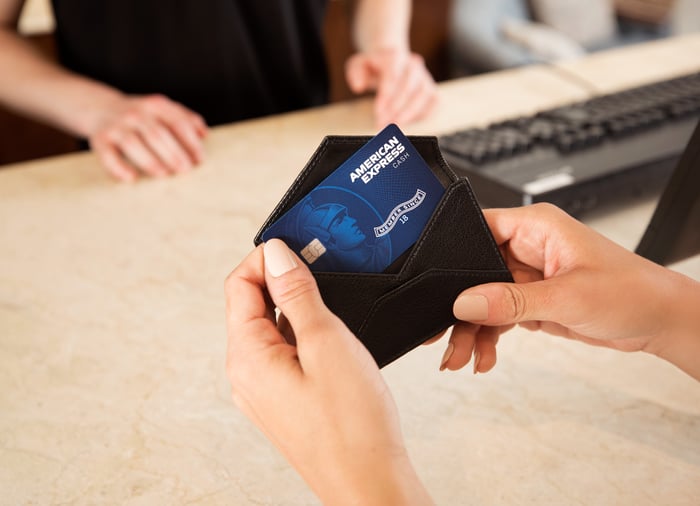 A shopper pulls an American Express credit card out of her wallet.