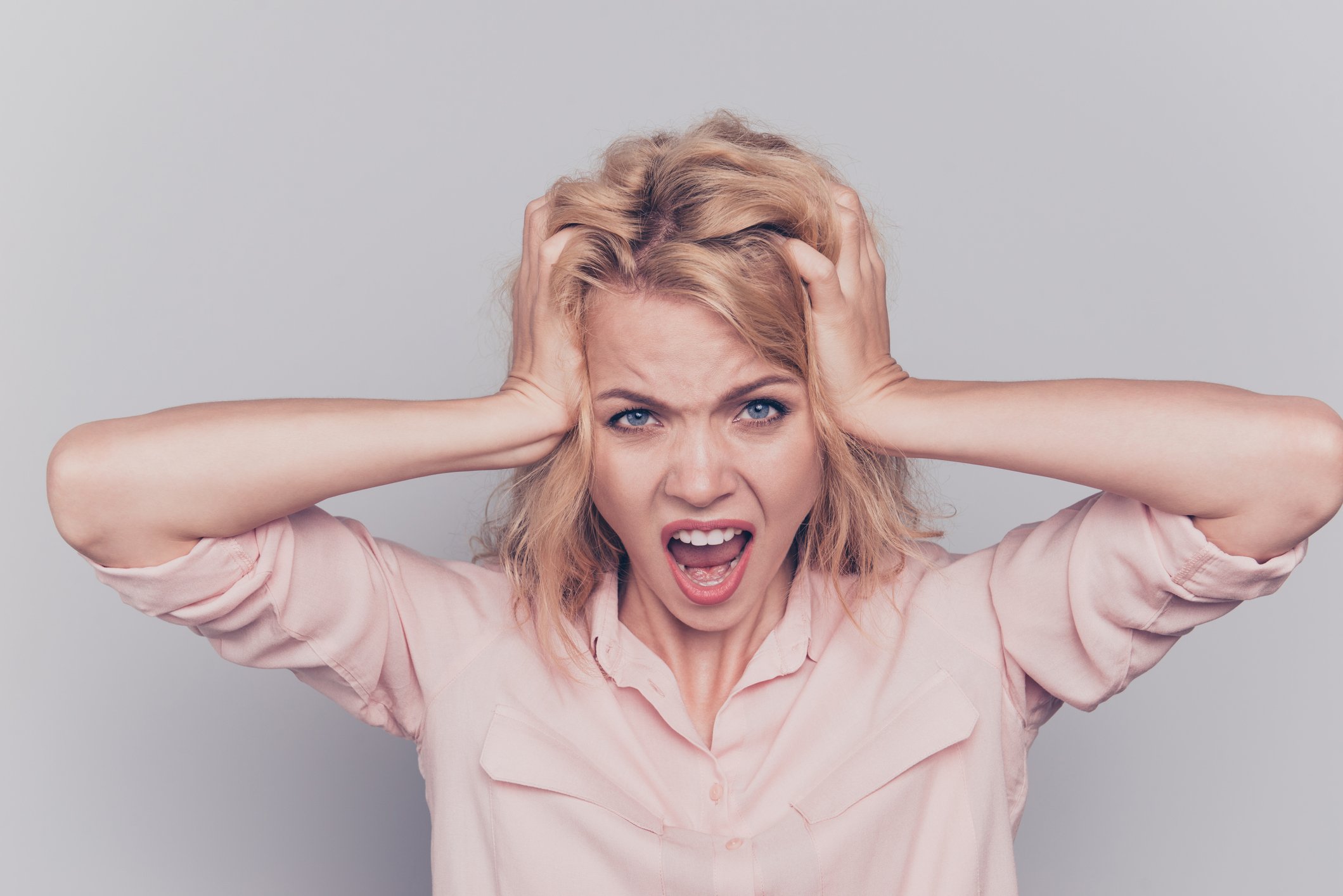 Person holding head with angry expression.