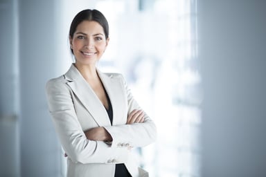 woman in business suit smiling with arms crossed