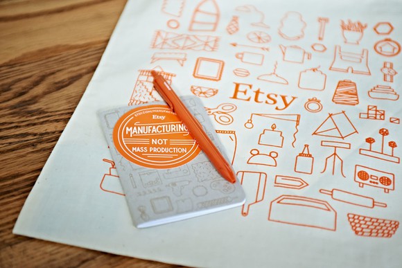 A notepad and pen as Etsy swag at a conference.