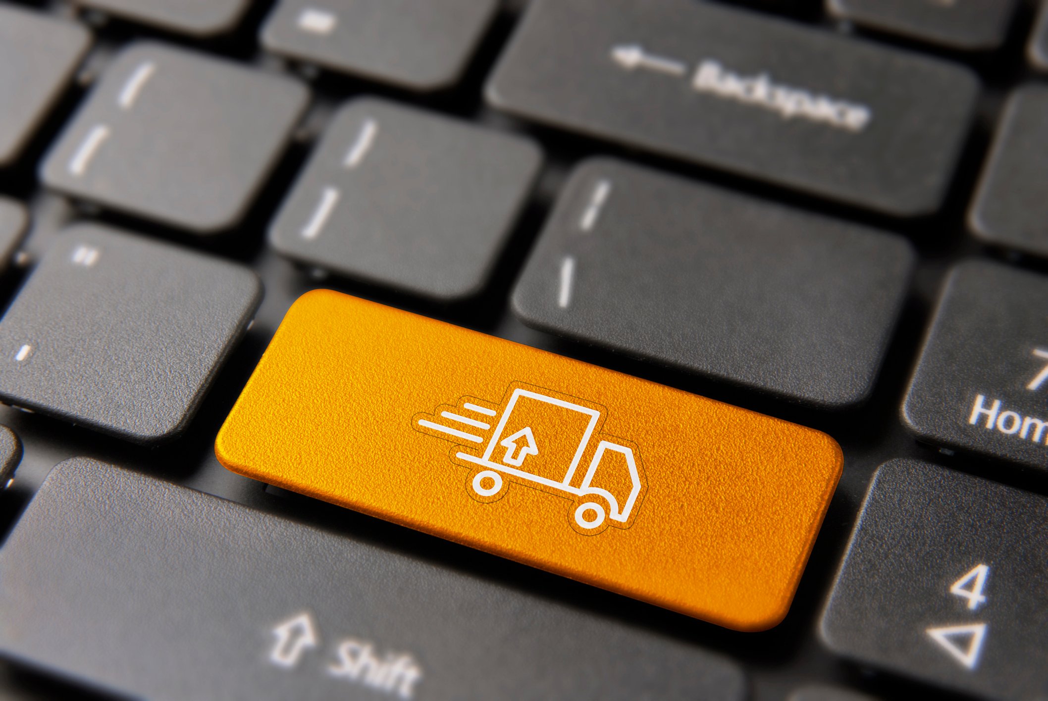 A computer keyboard with an image of a delivery truck placed over the enter key.