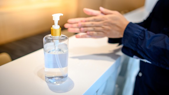 A person uses hand sanitizer