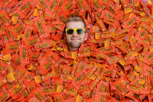 a Reese's fan is surrounded by packages of Reese's Cups