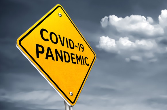 A road sign states COVID-19 pandemic.