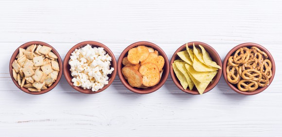 Bowls of crackers, pretzels, potato chips, and popcorn.