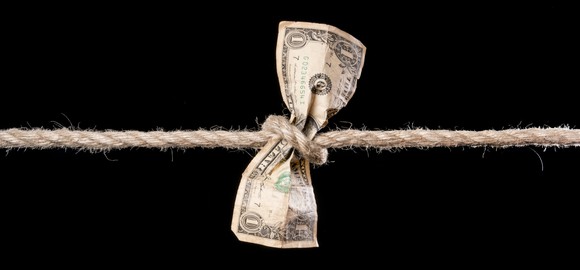 Rope strangles a dollar bill.