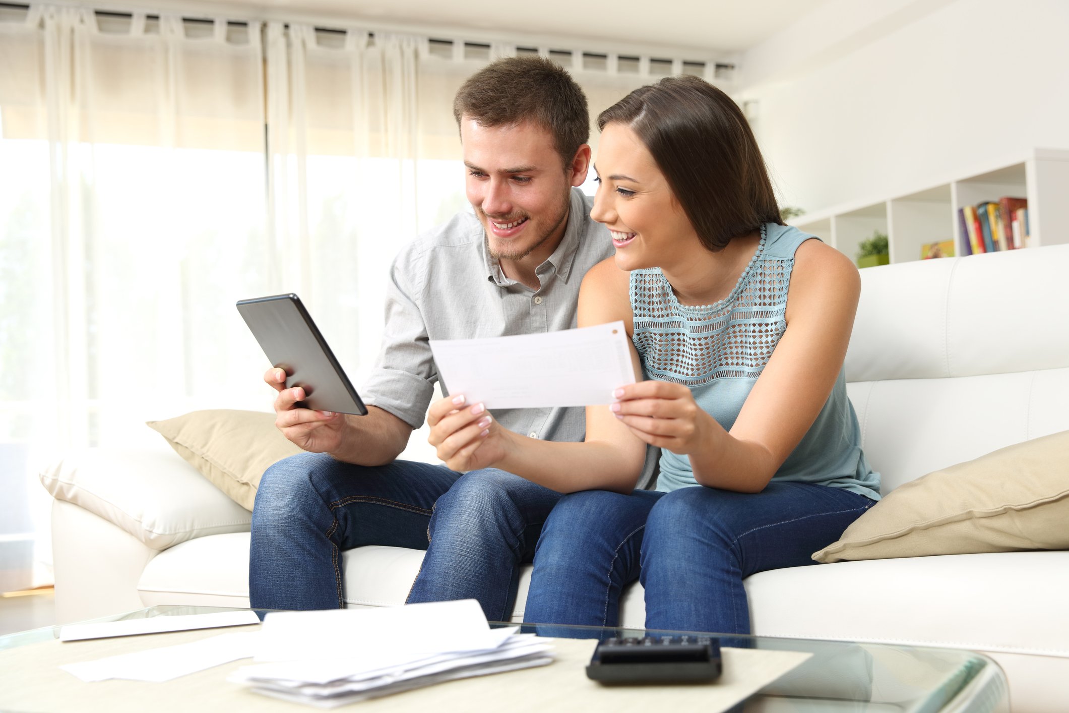 Young couple sitting on the couch looking at documents