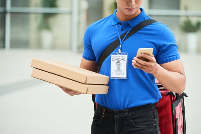 Pizza delivery guy consulting his online app