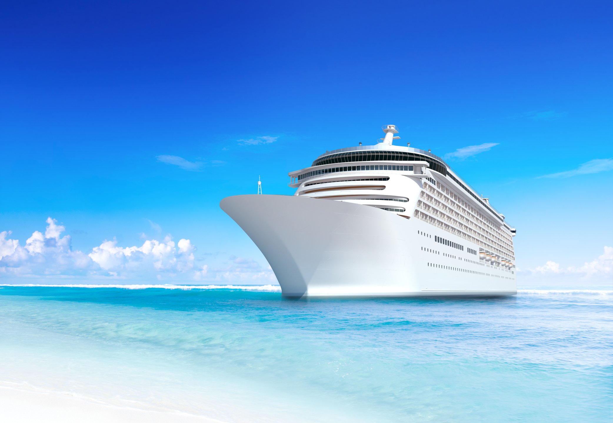 Cruise ship anchored near a beach on a sunny day. 