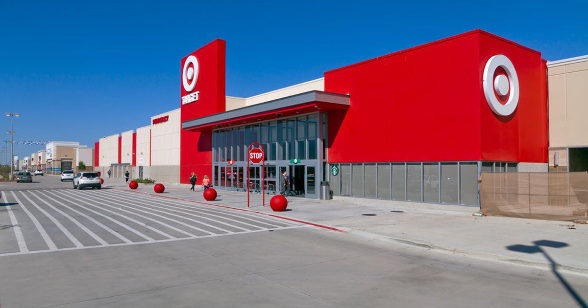 Target store location as seen from parking lot, with a few cars and blue sky.