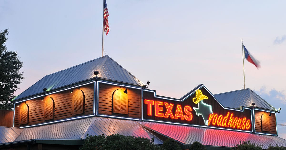 A Texas Roadhouse store with the sign over the door in focus.