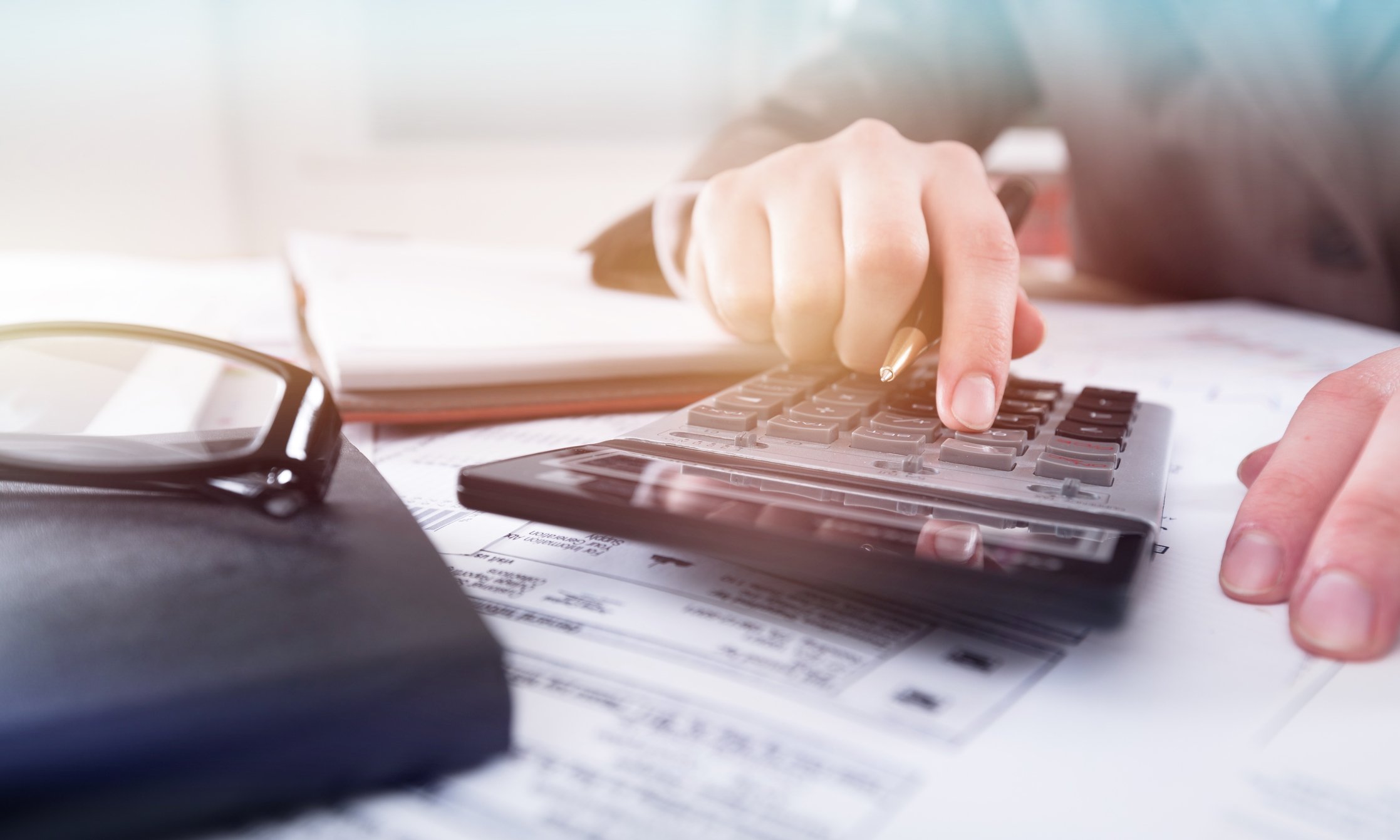 A person using a calculator at a desk
