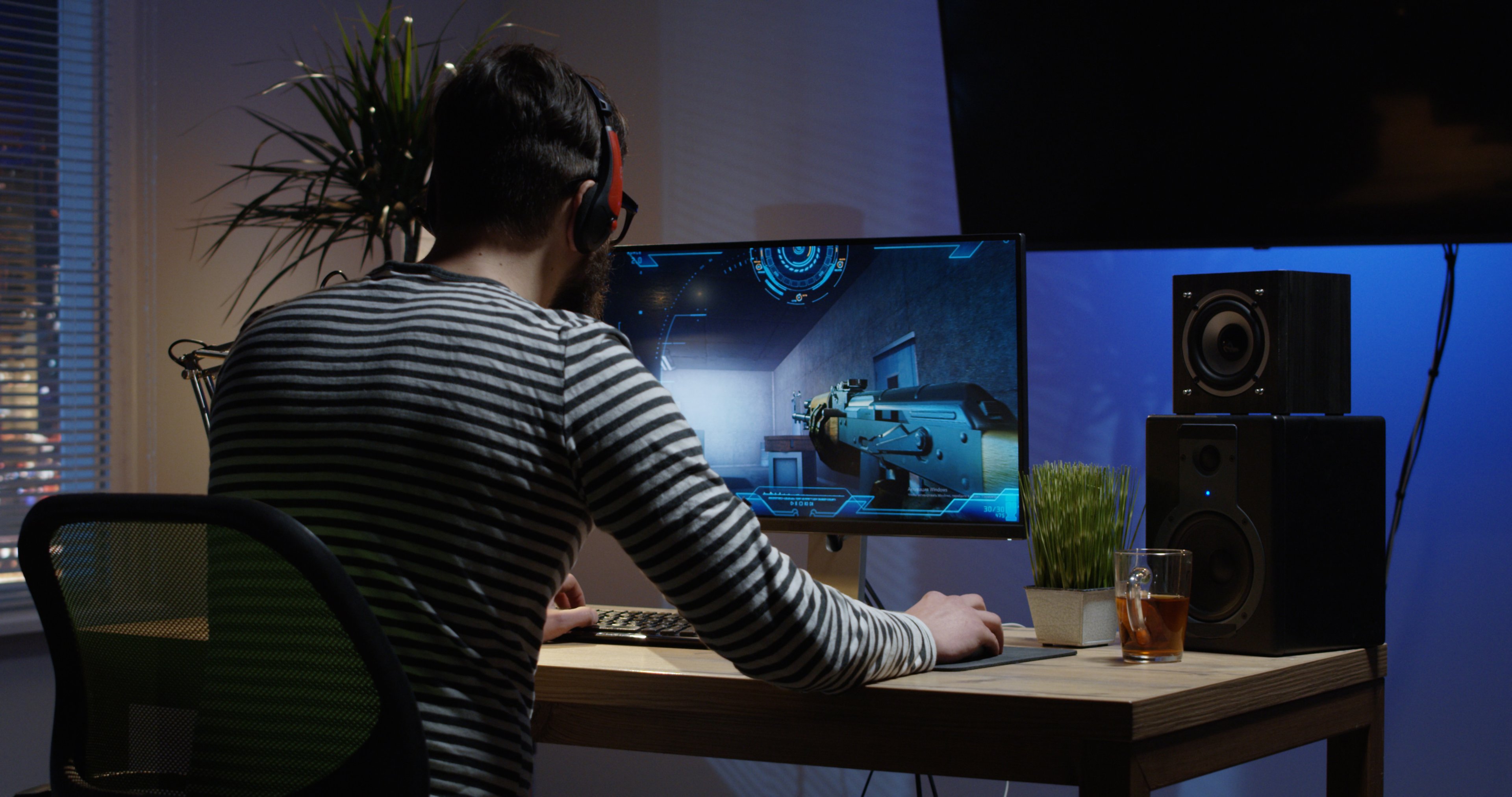Video game player at desk, playing a game.