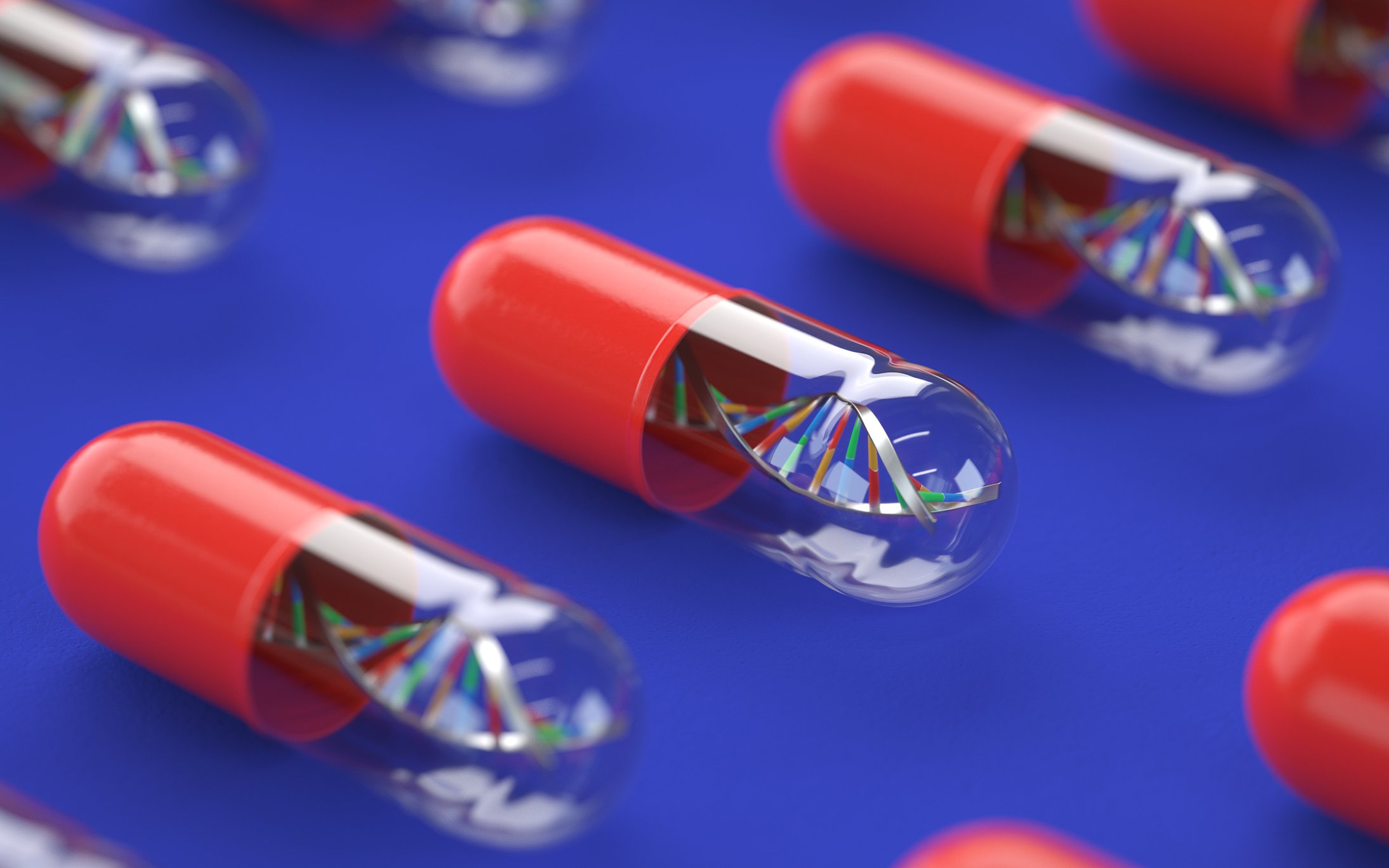 A picture of several pills lined up besides each other, each containing a DNA strand.