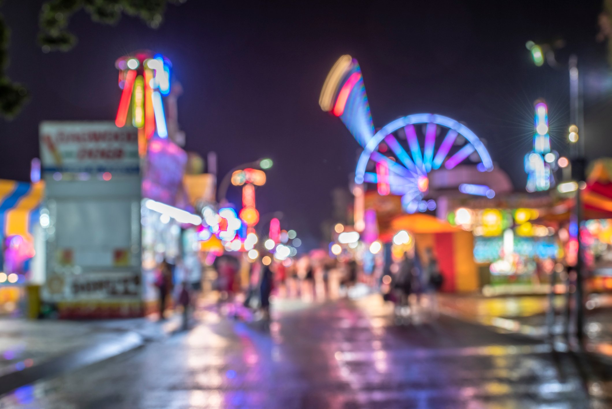 A blurry image of a theme park lit up at night.