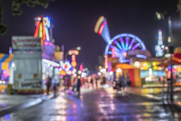 A blurry image of a theme park lit up at night.